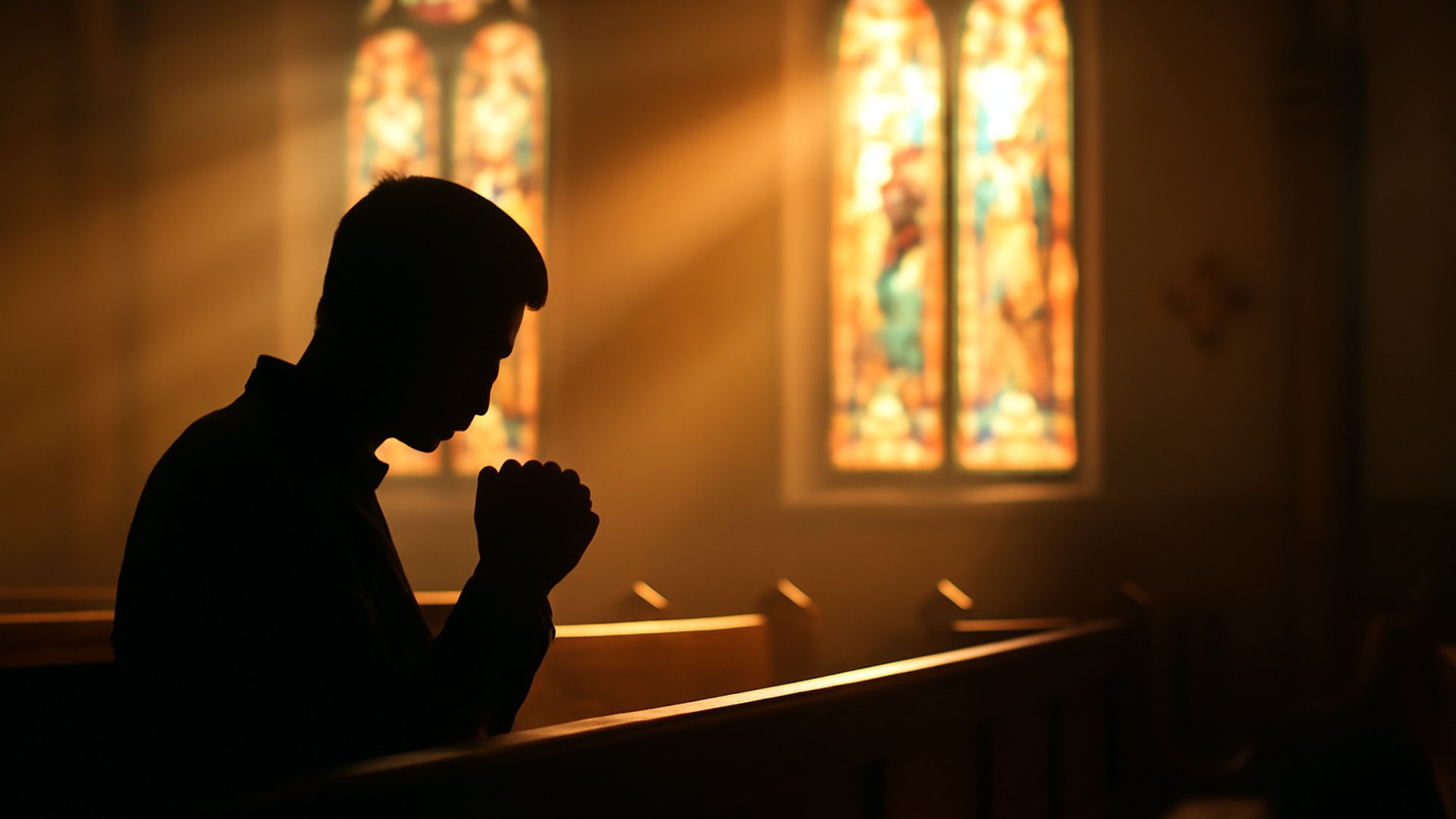 A peaceful church scene with sunbeams through stained glass